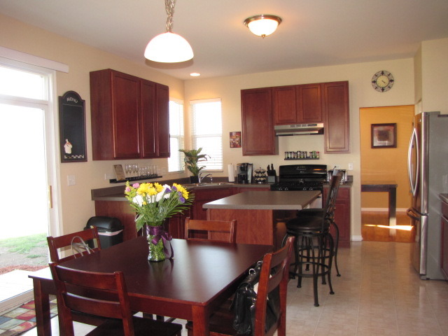 6403 Roth Court Joliet, IL 60431 - Photo 6 of 22 a kitchen with stainless steel appliances granite countertop a stove a refrigerator a sink a dining table and chairs