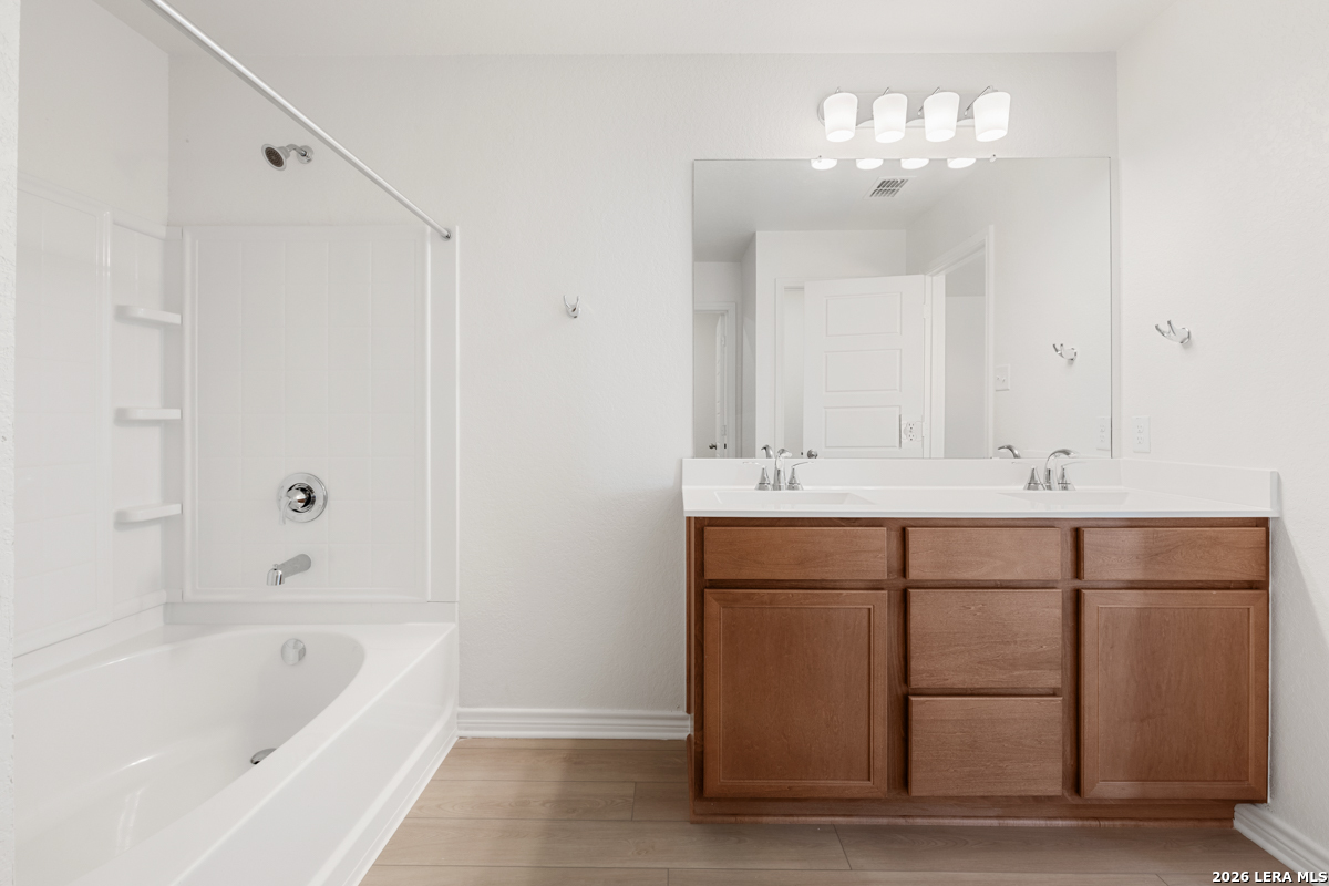 10045 Jagger Avenue Converse, TX 78109 - Photo 21 of 28 a bathroom with a sink double vanity and bathtub