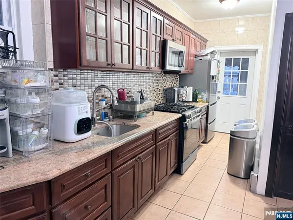 a kitchen with stainless steel appliances granite countertop a sink stove and cabinets