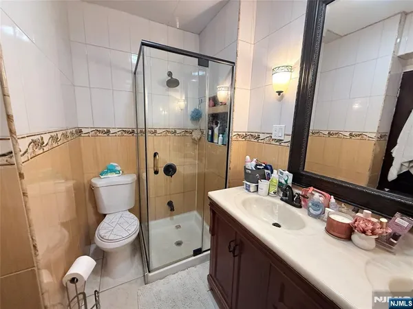 a bathroom with a sink vanity mirror toilet and shower