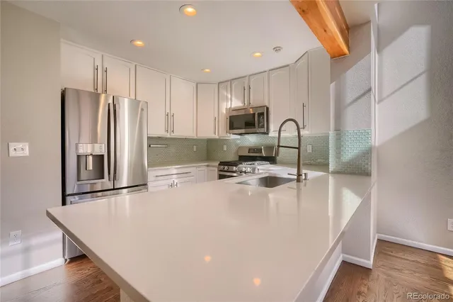 a view of a big room with windows and chandelier fan
