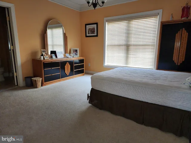a spacious bedroom with a bed and a large window