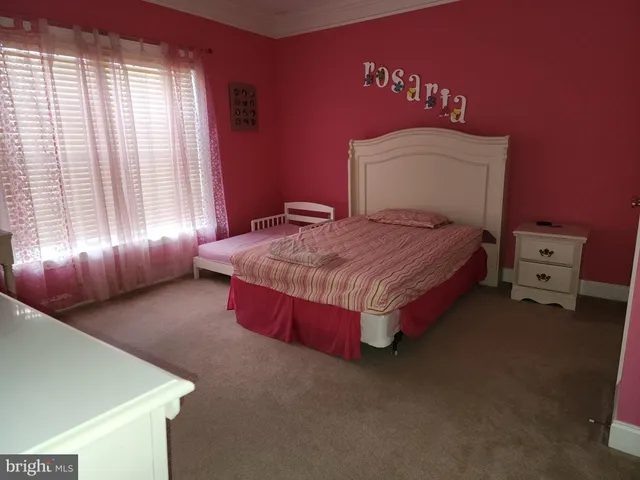 a spacious bedroom with a bed and window