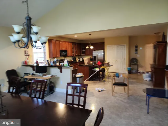 a living room with furniture kitchen view and a chandelier