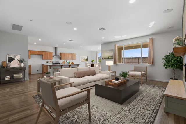 a living room with furniture kitchen view and a large window