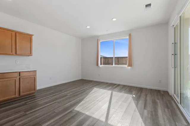 a large kitchen with stainless steel appliances kitchen island a large counter top and a wooden floors