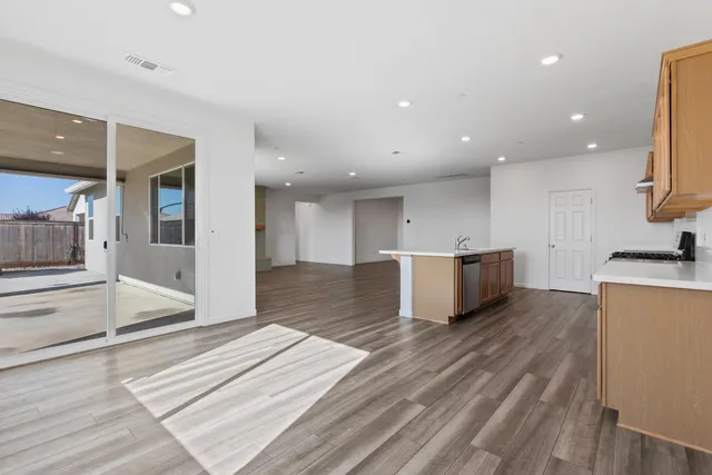a kitchen with stainless steel appliances granite countertop a sink and wooden floor