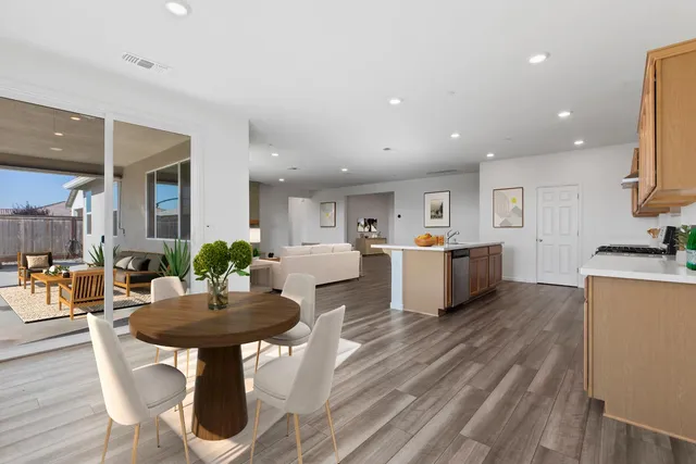 a kitchen with stainless steel appliances kitchen island dining table and chairs