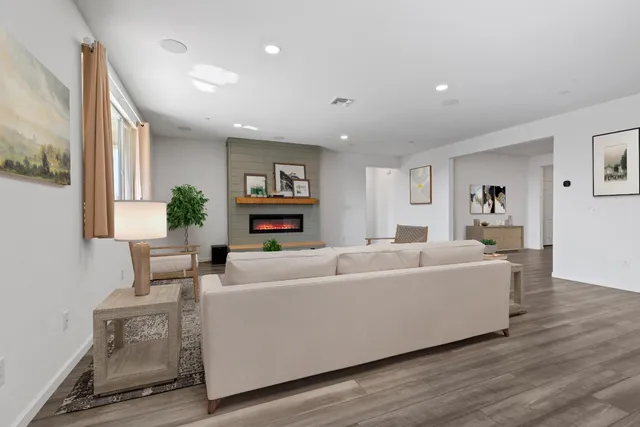 a living room with furniture a fireplace and a large window