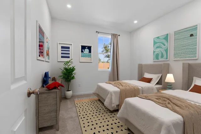 a bedroom with two beds and a potted plant