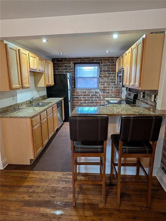 24 Daniel Street Southeast, Unit 4 Atlanta, GA 30312 - Photo 6 of 19 a kitchen with stainless steel appliances granite countertop a table chairs sink and cabinets