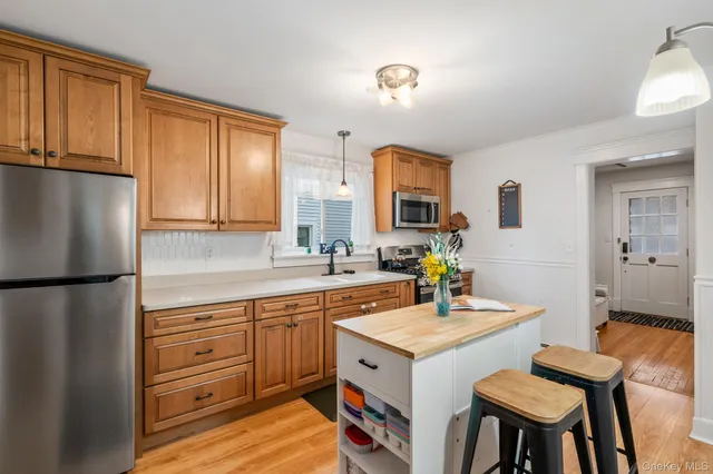 a view of a kitchen with fridge and wooden floor