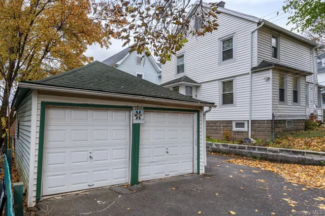 a view of a white house with a large tree