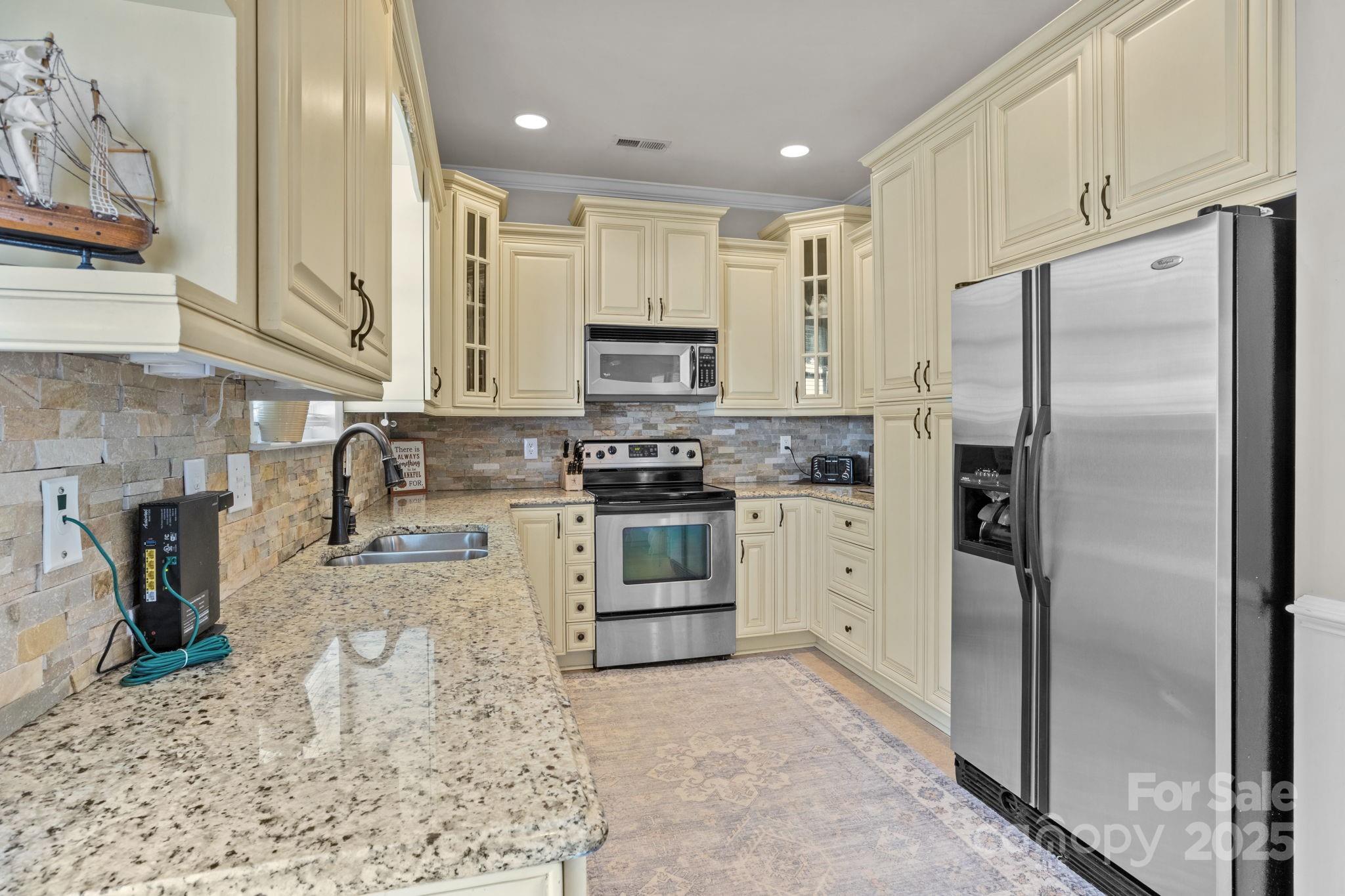 10825 Traders Court Davidson, NC 28036 - Photo 11 of 36 a kitchen with stainless steel appliances granite countertop a refrigerator a stove and a sink