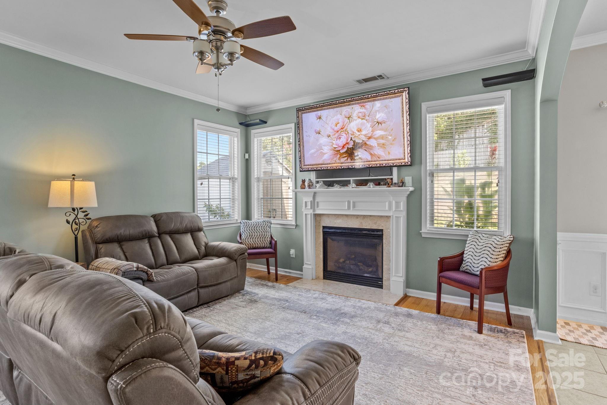 10825 Traders Court Davidson, NC 28036 - Photo 7 of 36 a living room with furniture a fireplace and a flat screen tv