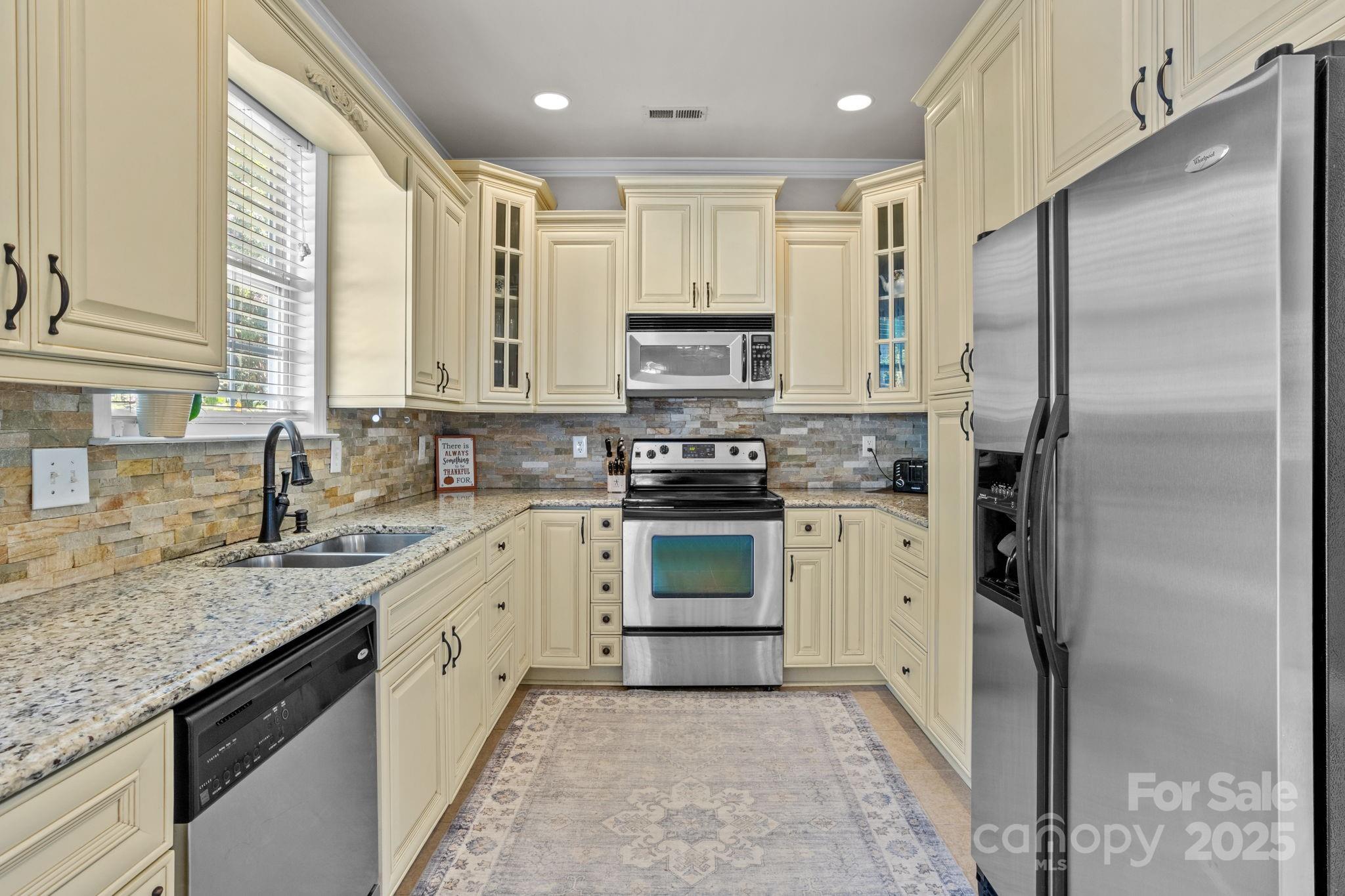 10825 Traders Court Davidson, NC 28036 - Photo 9 of 36 a kitchen with stainless steel appliances granite countertop a stove a sink and a refrigerator