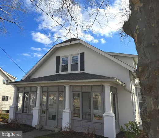 a yellow house with a tree in front of it