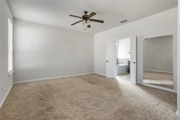 an empty room with closet and a chandelier fan