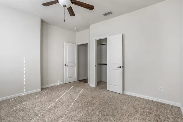 a view of empty room with ceiling fan