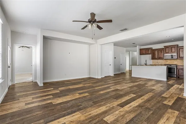a view of a livingroom with a ceiling fan hardwood floor and a ceiling fan