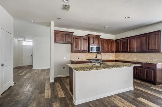 a kitchen with stainless steel appliances granite countertop a sink and cabinets