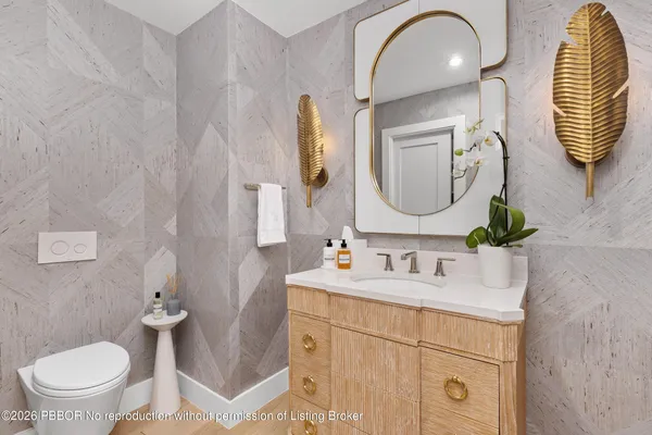 a bathroom with a toilet sink and mirror