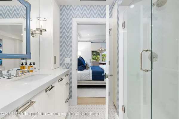 a en suite bathroom with a granite countertop sink and a mirror
