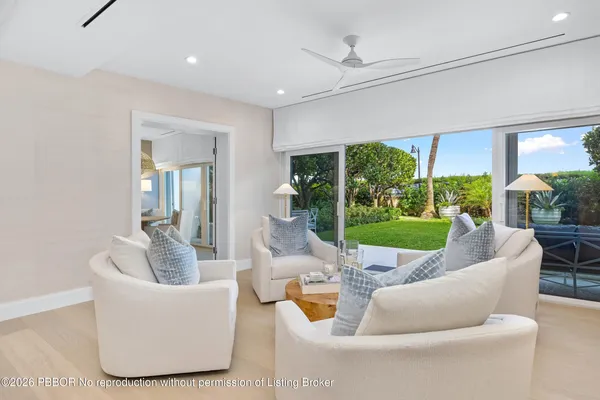 a living room with patio furniture and floor to ceiling window