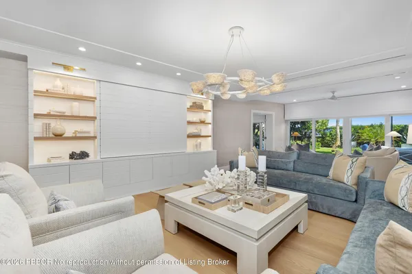 a living room with furniture a chandelier and a table