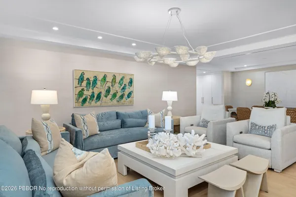 a living room with furniture a chandelier and a table
