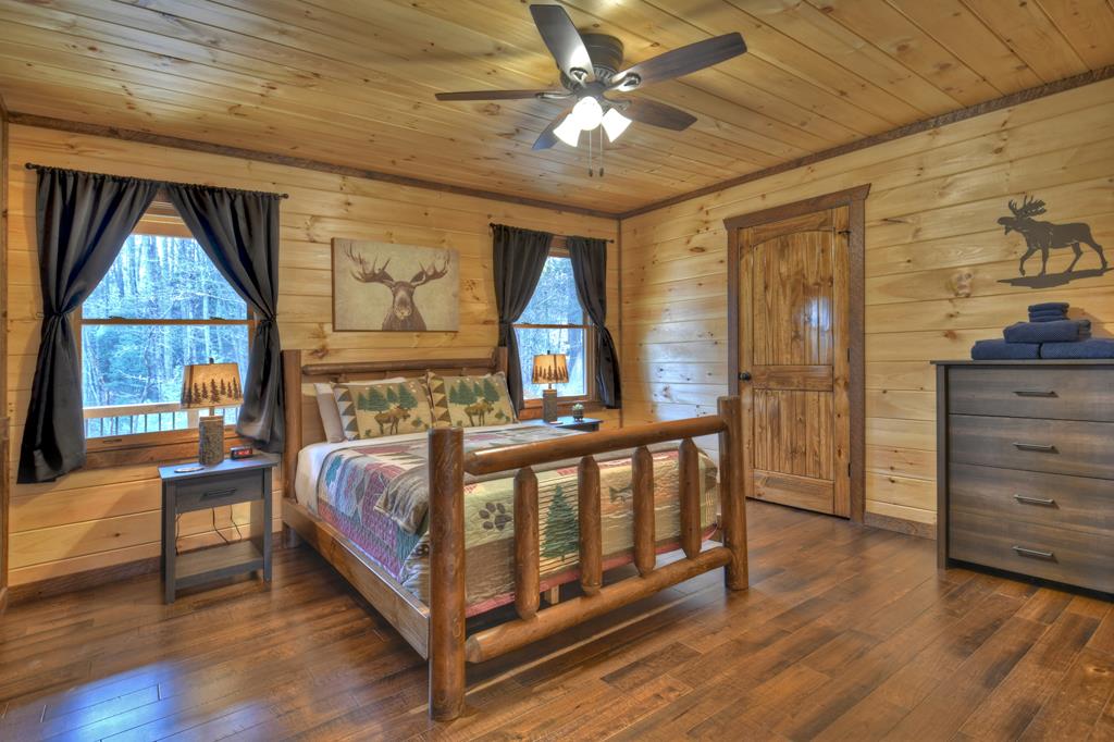 91 Heritage Way Cherry Log, GA 30522 - Photo 26 of 35 a bedroom with a bed next to a window with a flat tv screen and dresser