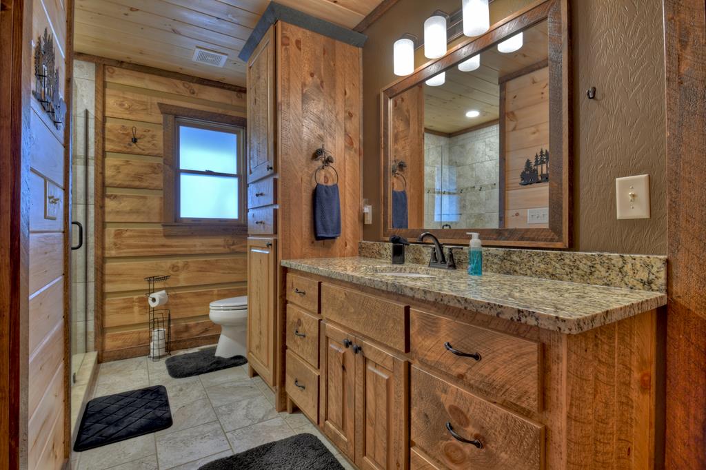 91 Heritage Way Cherry Log, GA 30522 - Photo 27 of 35 a bathroom with a granite countertop sink mirror and a toilet