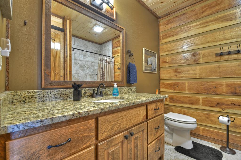 91 Heritage Way Cherry Log, GA 30522 - Photo 35 of 35 a bathroom with a granite countertop toilet a sink and a mirror