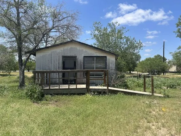a view of backyard with wooden fence and large trees