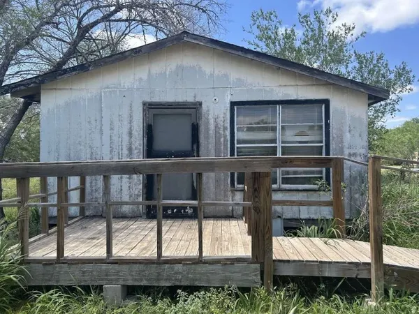 a view of wooden house with large windows and a table