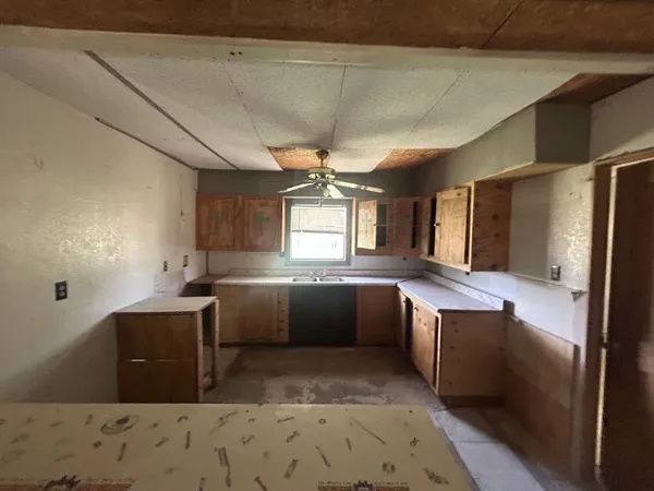 a kitchen with stainless steel appliances kitchen island granite countertop a sink and wooden cabinets