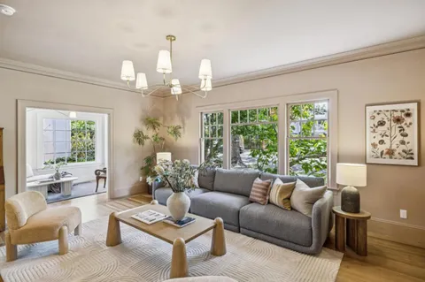 a living room with furniture chandelier and a large window
