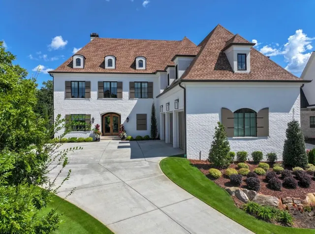 a front view of a house with a yard and potted plants