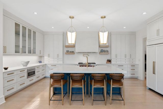 a kitchen with stainless steel appliances a stove and white cabinets
