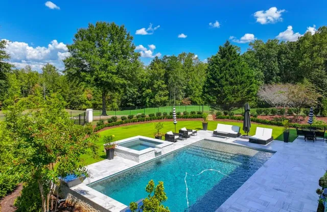 a view of a swimming pool with a patio and a yard