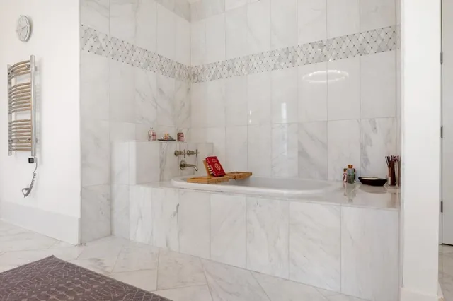 a spacious bedroom with a bed and a flat screen television