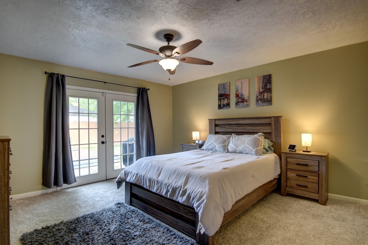 25810 Fairbrook Lane Spring, TX 77373 - Photo 20 of 33 This spacious bedroom features a cozy carpet, a ceiling fan, and ample natural light from glass doors leading to a private patio.