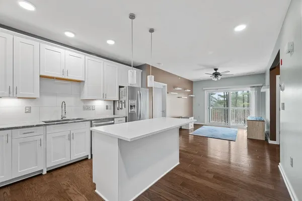 a large kitchen with stainless steel appliances lots of counter space and wooden floor