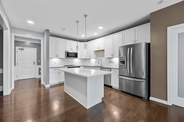 a kitchen with stainless steel appliances granite countertop a refrigerator a sink and a stove