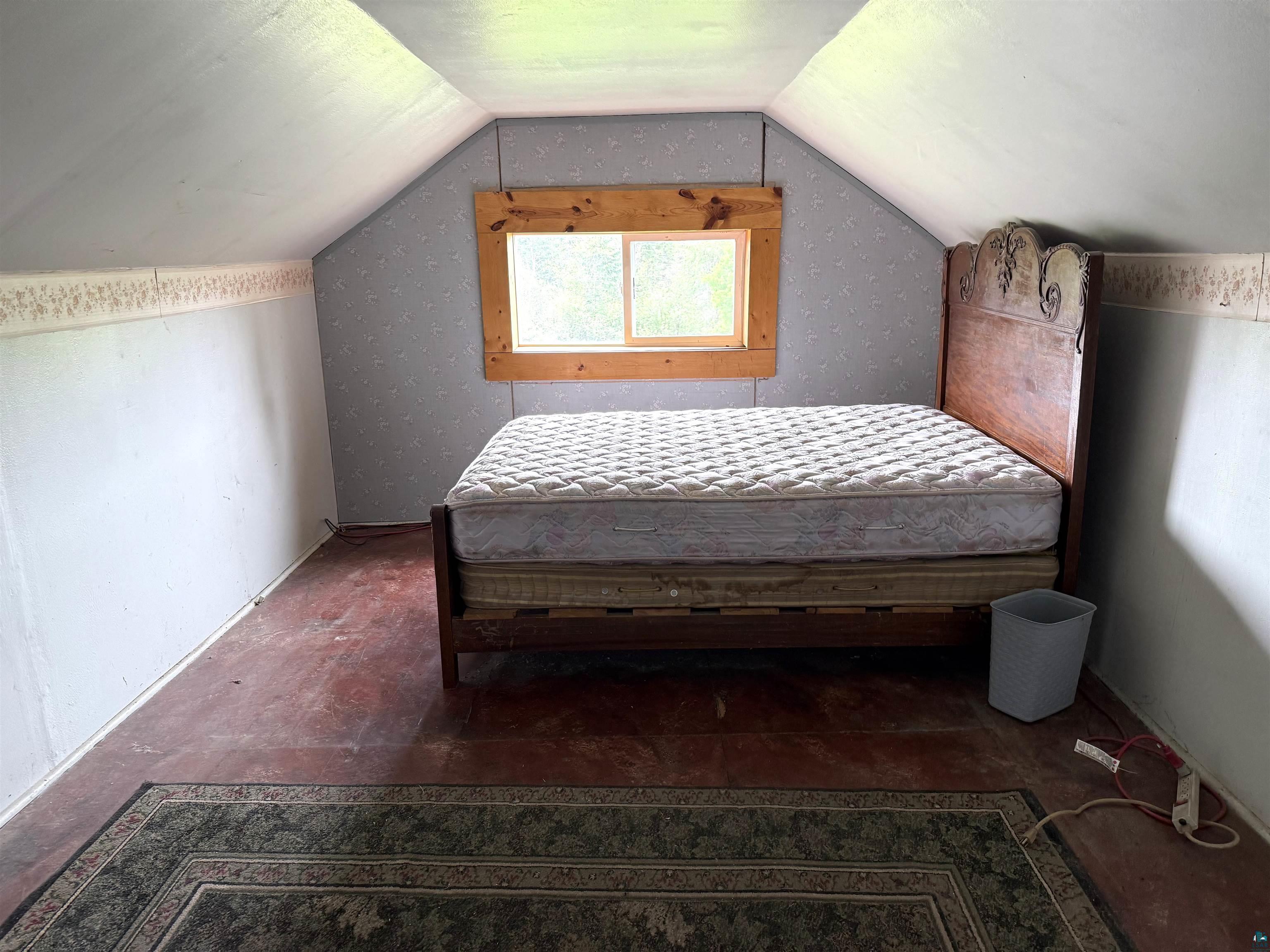 3541 Bent Trout Lake Road Barnum, MN 55707 - Photo 24 of 41 Attic space featuring sloped ceilings, a single window with wood trim, and a hard surface floor