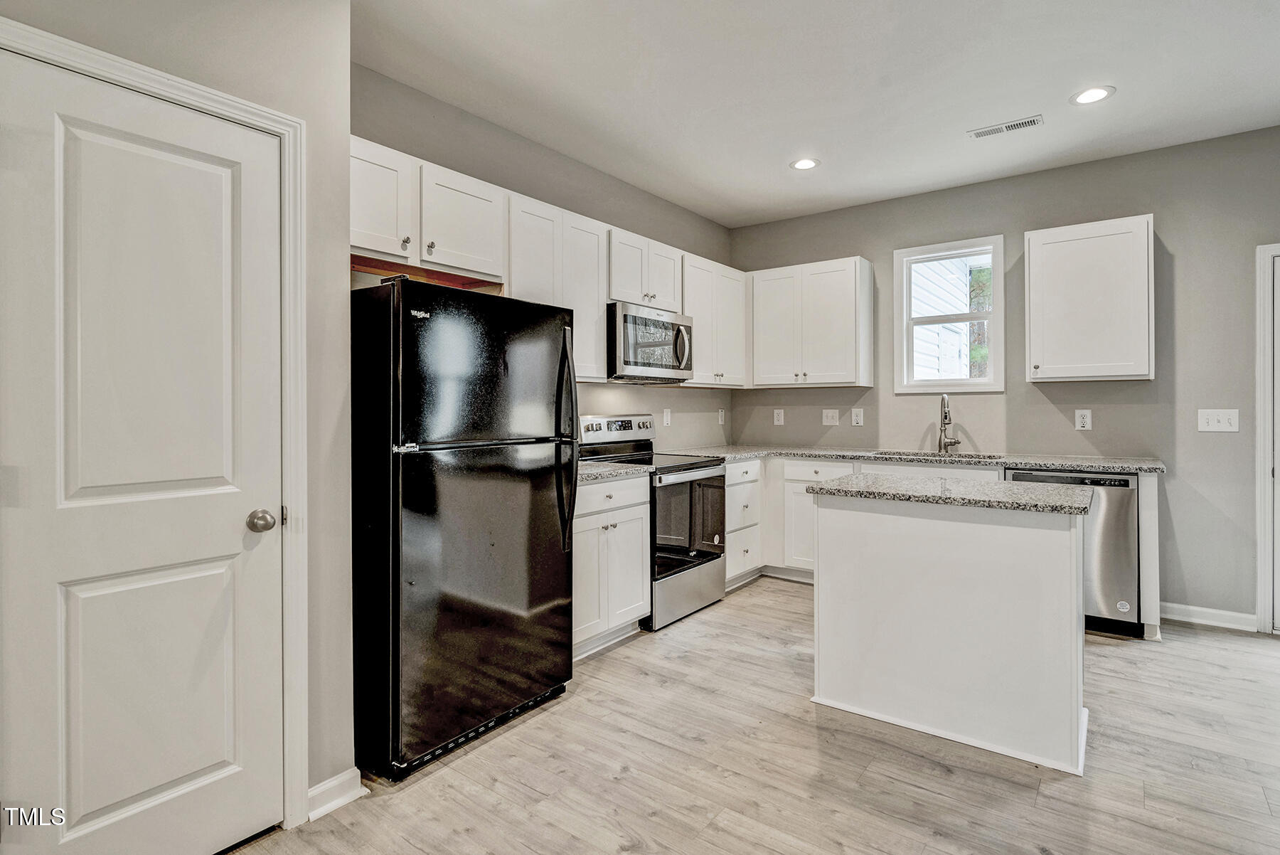 67 Stewarts Knob Drive Clayton, NC 27527 - Photo 11 of 26 a kitchen with a refrigerator sink and cabinets