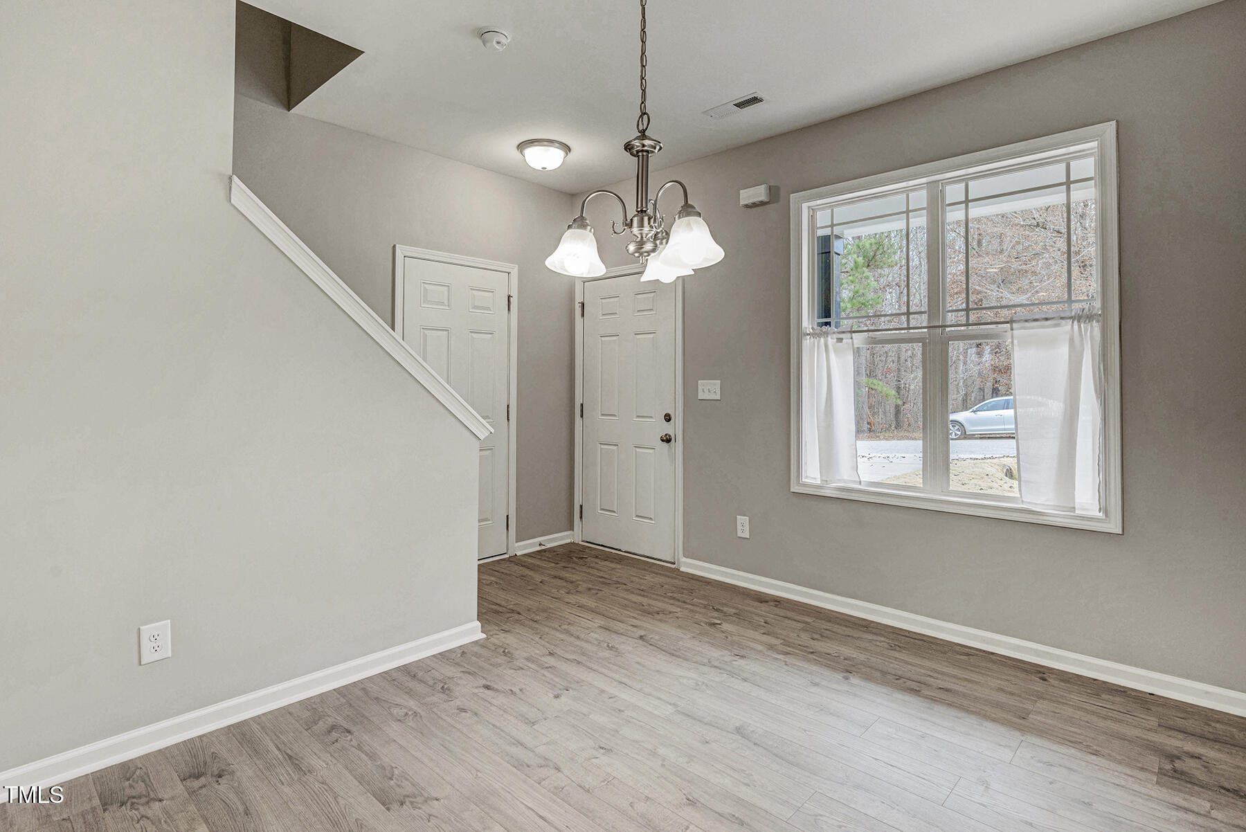 67 Stewarts Knob Drive Clayton, NC 27527 - Photo 12 of 26 a view of an empty room with wooden floor and a window
