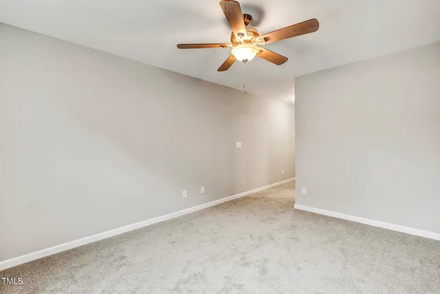 an empty room with a window and a ceiling fan
