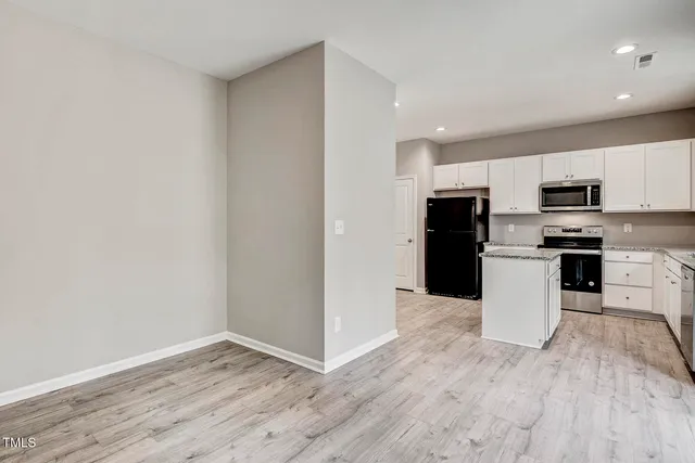 a kitchen with wooden floors and appliances