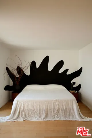 a bedroom with a bed and a painting on the wall